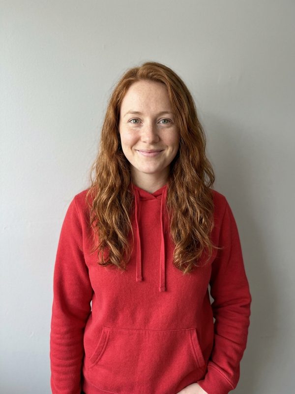 Foto real: mujer pelirroja con sudadera roja